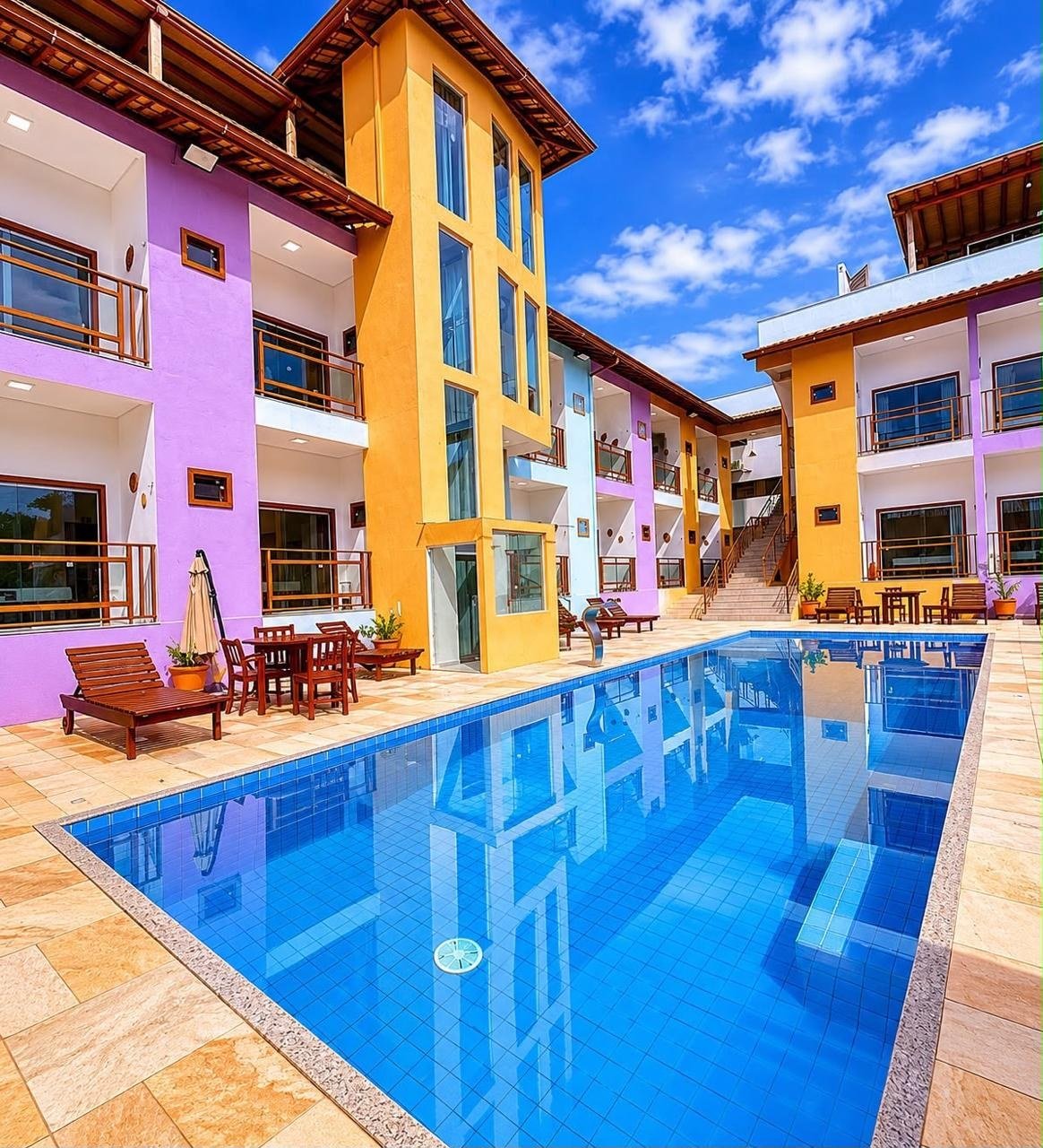 Área externa da Pousada Damasco com piscina e fachada colorida